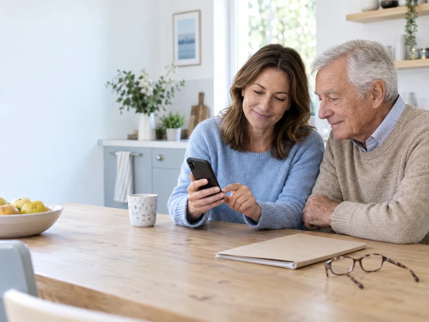 An adult helping an older parent review family health records on a smartphone
